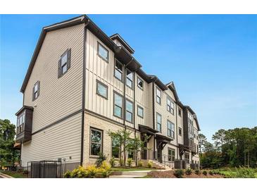 Beautiful townhome exterior shows modern design with a combination of siding, brick and manicured landscaping at 1283 Forsyth Park Rd, Decatur, GA 30033