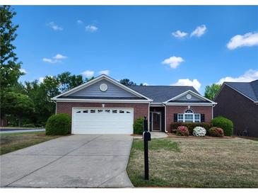 Charming one-story brick home with a two-car garage and beautifully landscaped front yard at 1705 Rolling View Dr, Cumming, GA 30040