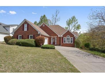 Charming red brick home features a manicured lawn, mature landscaping, and traditional architectural details at 625 Sycamore Glen Nw Ct, Lawrenceville, GA 30044