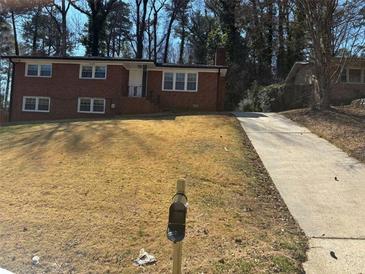 Charming two-story brick home with a long driveway and well-manicured front lawn at 2703 Rainbow Forest Dr, Decatur, GA 30034