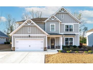 Charming two-story home with a two-car garage, landscaped yard, and classic architectural details at 7545 Rambling Vale, Cumming, GA 30028