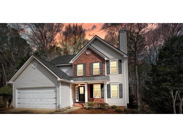 Two-story home showcasing charming brick accents, a well-manicured lawn, and a two-car garage at 802 Eagle Glen Xing, Woodstock, GA 30189