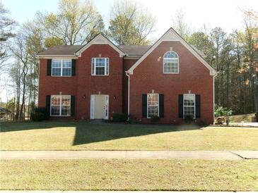 Charming two-story brick home with a well-manicured lawn and classic architectural details at 1211 Saxony Se Dr, Conyers, GA 30013