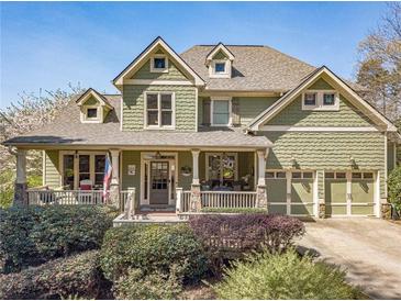 Charming two-story home with a welcoming front porch, lush landscaping, and an attached two-car garage at 3828 Morning Meadow Ln, Buford, GA 30519