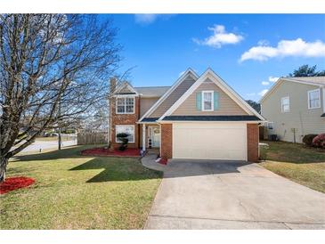 Charming two-story home with a well-manicured lawn, landscaping, and a two-car garage at 401 Windstream Sw Dr, Marietta, GA 30060