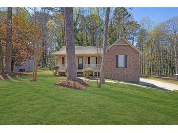 Charming brick and siding home with a well-maintained front yard and covered porch at 8633 Hilltop Rd, Jonesboro, GA 30236