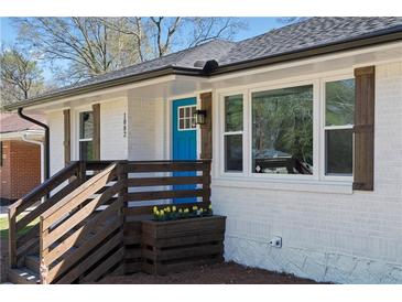 Charming white brick home features a bright blue front door and wooden porch at 1882 Rosewood Rd, Decatur, GA 30032