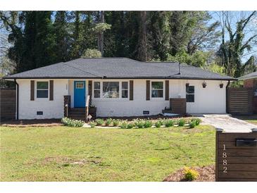Charming home with a well-manicured lawn and a bright blue front door, creating a welcoming curb appeal at 1882 Rosewood Rd, Decatur, GA 30032