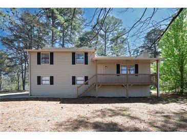Charming split-level home featuring a welcoming front porch and neutral siding with black shutters at 4130 N Quail Dr, Douglasville, GA 30135