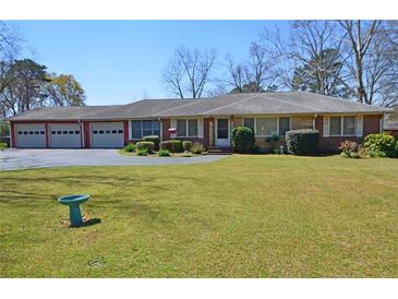 Charming single-story home with a brick facade, well-maintained lawn, and a spacious four-car garage at 3528 Highway 42 S, Locust Grove, GA 30248
