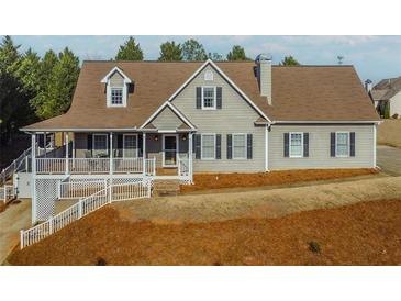 Charming home featuring a well-maintained lawn, cozy front porch, and classic architectural details at 1019 Walnut Creek Dr, Woodstock, GA 30188