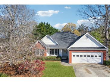 Charming single-story home with brick accents, lush lawn, and attached two-car garage at 115 Dearing Woods Way, Covington, GA 30014