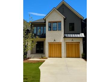 Charming two-story home featuring a mix of brick and siding, complemented by wooden garage doors at 2583 Apple Valley Rd, Brookhaven, GA 30319