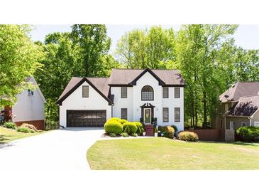 Charming two-story home with a well-manicured lawn and lush green trees at 3612 Tree View Dr, Snellville, GA 30078