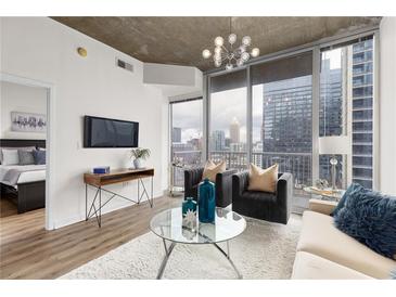 Bright living room with city views, modern furnishings, and hardwood flooring at 855 Peachtree Ne St # 1508, Atlanta, GA 30308