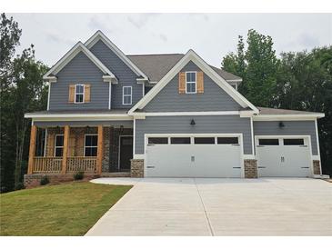 Charming two-story home featuring a three-car garage, covered front porch, and attractive gray siding at 174 Pinewood Dr, Covington, GA 30014