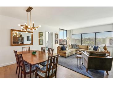 Open-concept living area with dining table, modern lighting, and large windows for natural light at 1130 Piedmont Ne Ave # 907, Atlanta, GA 30309