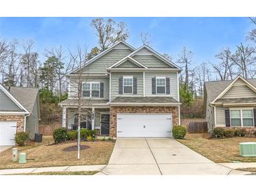 Charming two-story home with a two-car garage, stone accents, and landscaped front yard at 133 Prominence Ct, Canton, GA 30114