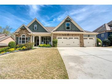 Charming two-story home with stone accents, three-car garage, and landscaped front yard under a blue sky at 161 Dorys Way, Dallas, GA 30157