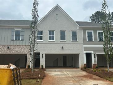 New construction townhomes with gray and white brick and siding exteriors and two car garages at 125 Priestwood Ln, Acworth, GA 30102