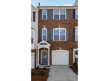 Charming brick townhouse with a one-car garage and a welcoming blue front door at 3182 Mill Springs Cir, Buford, GA 30519