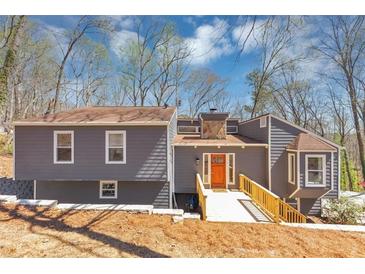 Charming gray home with a wooden walkway and a welcoming orange front door, perfect for any homeowner at 980 Pine Grove Pointe Dr, Roswell, GA 30075