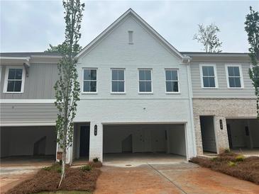 Modern townhome exterior with white brick, large windows, and a two-car garage at 105 Priestwood Ln, Acworth, GA 30102