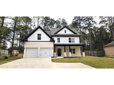 Two-story home featuring a brick and white exterior with a two car garage and a charming front porch at 355 Hilltop Cir Sw Ext, Mableton, GA 30126