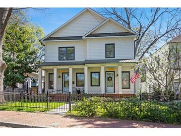 Charming two-story home featuring a well-manicured lawn and a welcoming front porch with stately columns and black framed windows at 273 Glenwood Se Ave # B, Atlanta, GA 30312