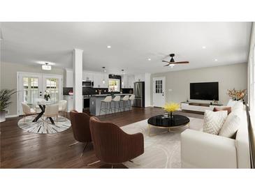 Open-concept living room and kitchen with stainless steel appliances, island seating, and a modern design at 3376 Irish Ln, Decatur, GA 30032