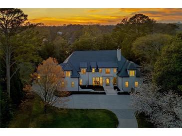 Stunning traditional style home at sunset with manicured landscaping and an extended driveway at 3364 Knollwood Nw Dr, Atlanta, GA 30305