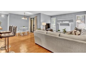 Open living room with hardwood floors, white fireplace, and access to a private outdoor patio at 1281 Branch Dr, Tucker, GA 30084