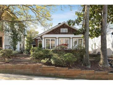 Charming home showcasing a well-maintained front yard with mature trees and professional landscaping at 573 Amsterdam Ne Ave, Atlanta, GA 30306