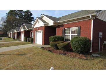 A charming one-story red brick house with a well-manicured lawn and an attached garage at 238 Valley Hill Road Rd, Riverdale, GA 30274
