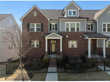 Charming townhome with a red brick facade, black shutters and a landscaped yard at 2736 Bell Se Dr, Smyrna, GA 30080