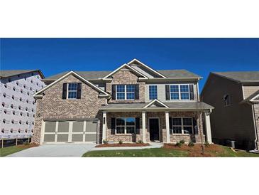 Beautiful brick two-story home with a covered front porch and two-car garage, perfect for Gathering living at 3718 Southfield Ct, Loganville, GA 30052