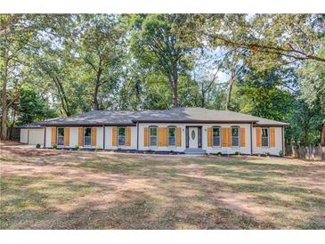 Charming single-story home with white facade, wood shutters and lush green trees at 105 Simonton (Tract 1) Se Rd, Lawrenceville, GA 30046
