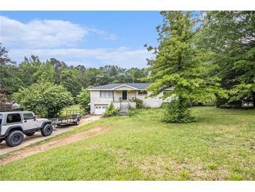 A charming brick ranch-style home with a spacious front yard and mature trees at 8600 Andy Mountain Ct, Villa Rica, GA 30180