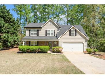 Charming two-story home with a well-maintained lawn, attached garage, and mature trees at 4315 Summit Heights Dr, Snellville, GA 30039