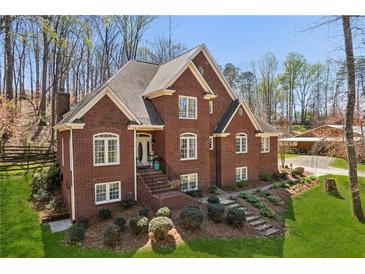 Inviting brick home with manicured lawn and landscaping in a beautiful wooded setting at 5388 Frazer Rd, Buford, GA 30518