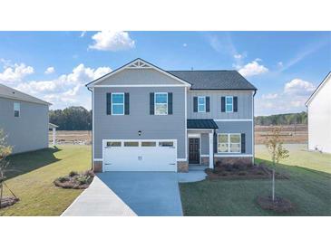 Charming two-story home with a two car garage, manicured lawn, and neutral toned siding at 1622 Palladian Way, Lithonia, GA 30058