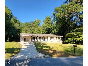 Charming single story home with a well manicured lawn, long driveway, and mature trees at 3263 Dodson Dr, Atlanta, GA 30344