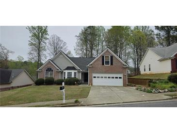 Charming brick and gray siding home with an attached two-car garage, complemented by mature landscaping at 5763 Dexters Mill Pl, Buford, GA 30518