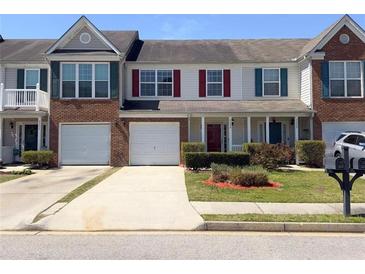 Inviting townhome with a one-car garage, manicured lawn, and colorful window shutters at 7229 Georges Way, Morrow, GA 30260