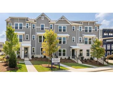 Modern townhouse exteriors showcasing gray siding, white brick accents, and well-manicured landscaping at 113 Chestnut Trce # 8, Hapeville, GA 30354