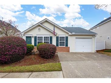 Charming home featuring a well-maintained front yard with flowering bushes and an attached garage at 115 Oak Grove Pl, Acworth, GA 30102