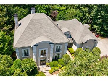 Stately home with lush landscaping, featuring a gray roof and elegant architectural details at 2005 Westbourne Way, Alpharetta, GA 30022