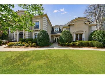 Elegant two-story home with a lush green lawn and meticulously manicured landscaping at 2005 Westbourne Way, Alpharetta, GA 30022