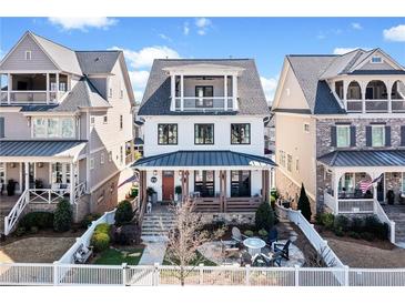 Charming home with a cozy front porch and upper balcony, surrounded by well-maintained landscaping and a white picket fence at 561 S Club Dr, Woodstock, GA 30188