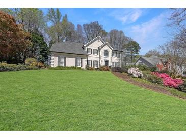 Charming two-story traditional home with manicured front lawn and colorful azaleas at 1201 Lake Washington Dr, Lawrenceville, GA 30043